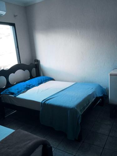 a bedroom with a bed with blue sheets and a window at Hotel center Ribeirão in Ribeirão Preto