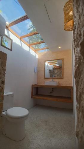 a bathroom with a toilet and a sink and a mirror at Morgans Bungalows in Maluk