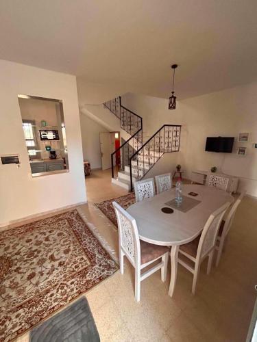 a dining room with a table and chairs and a staircase at djerba palm house in Mezraya