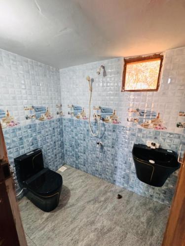 a bathroom with a shower and a toilet and a sink at Wild Roots Cabana Arugambay in Arugam Bay
