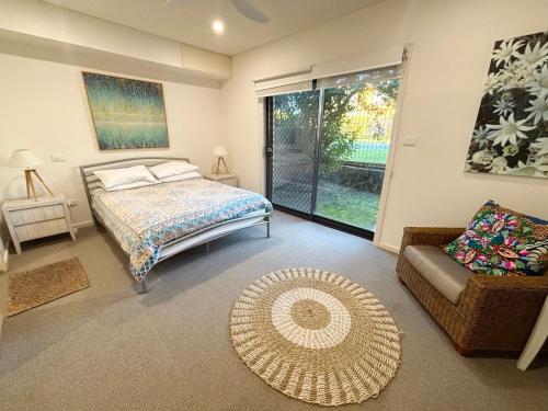 a bedroom with a bed and a couch and a window at Watermark Apartment 2 - Bring your own linen. in South West Rocks