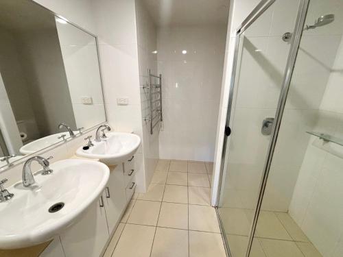 a bathroom with two sinks and a shower at Watermark Apartment 2 - Bring your own linen. in South West Rocks