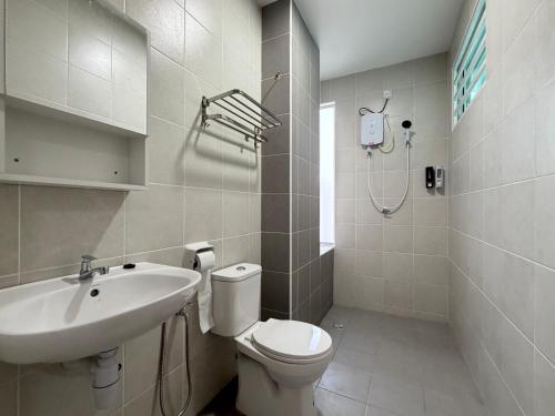 a white bathroom with a sink and a toilet at 4B 3R Cozy Spacious Near Dewan Millenium Fully Aircond in Kepala Batas