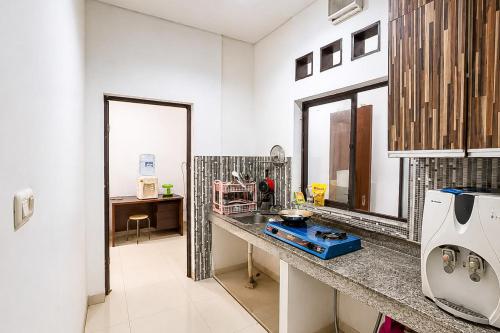 a kitchen with a sink and a counter top at RedDoorz at Residence Bintaro in Mencil