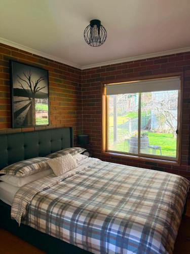 a bedroom with a bed and a large window at Noojee Getaway in Noojee