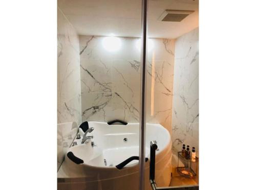 ein Badezimmer mit einem weißen Waschbecken in der Dusche in der Unterkunft ロコズリゾートハワイandオアフ in Honjo