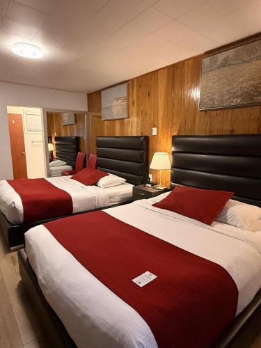 a hotel room with two beds with red and white sheets at Mountain View Hope Motel in Hope