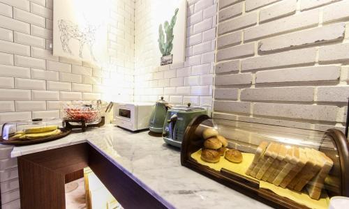 a kitchen with a counter with bread and a toaster at Brooks Hotel Tongyeong in Tongyeong