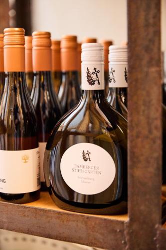 a row of bottles of wine on a shelf at Hotel & Restaurant Rhönhäuschen in Bischofsheim an der Rhön