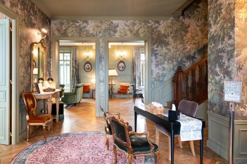 a living room with a wall covered in floral wallpaper at Villa Edmond Hôtel & Spa - Maison Blanche Bièvres in Bièvres