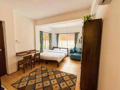 a living room with a bed and a desk at Studio By The Garden in Jawlakhel