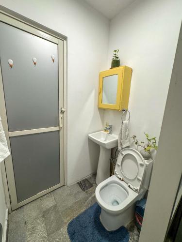 a bathroom with a toilet and a sink with a mirror at Studio By The Garden in Jawlakhel