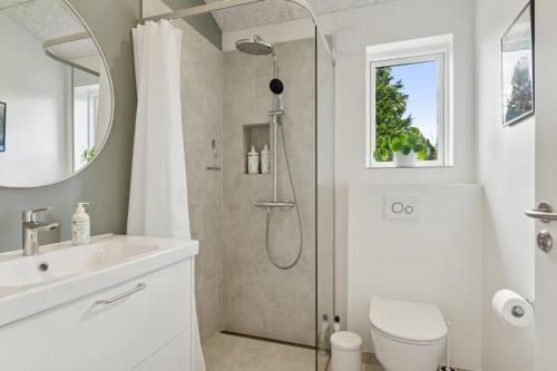 a bathroom with a shower and a toilet and a sink at Spacious Holiday Home On Bogø in Bogø By