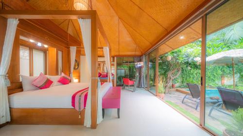 a bedroom in a villa with a bed and a patio at Pattaya Bungalow II, Totally Private Pool in Pattaya South