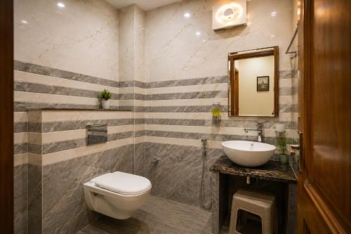 a bathroom with a toilet and a sink at The Ushmaya Lifestyle Wellness Resort Near Rishikesh in Haridwār