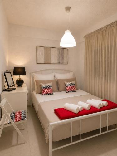 a bedroom with a large bed with red and white pillows at NiRa house in Pefkochori