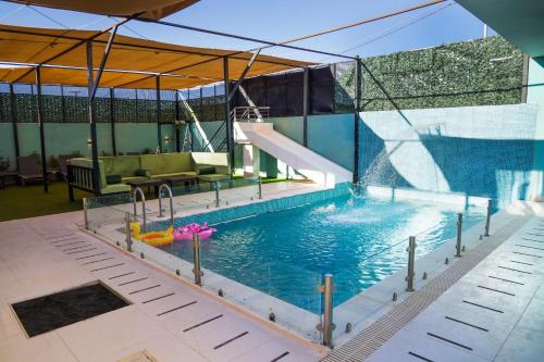 a swimming pool with a slide in a building at Airport Chalet مزرعة وشاليه المطار in Amman
