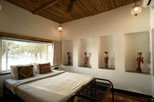 a bedroom with a bed with a window and vases on the wall at Paddy's Loft The Lake B&B in Udaipur