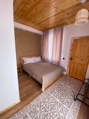 a bedroom with a bed and a door and a rug at Sarala Resort in Ostrov Kayrak