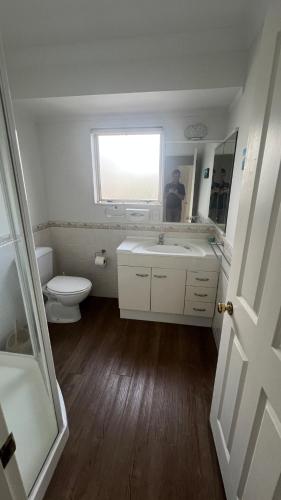a bathroom with a white sink and a toilet at Beachside Bliss in Tauranga