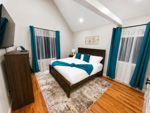 a bedroom with a bed with blue curtains and a television at Private 1BR Apt, WiFi, Reliable, Near NYC in Scotch Plains