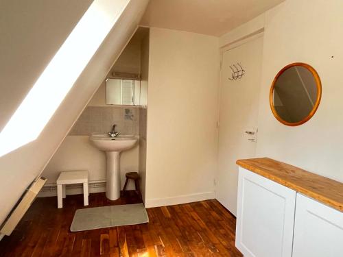 a bathroom under the stairs with a sink and a mirror at La P'tite Bouriane in Le Vigan