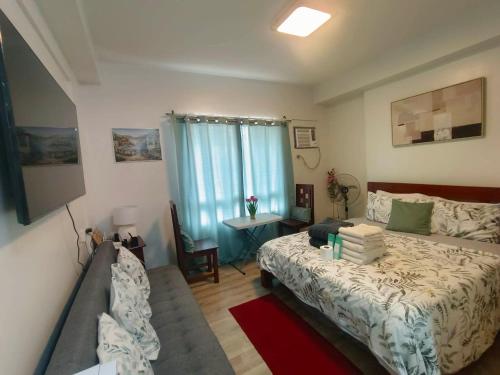 a bedroom with a bed and a table and a window at Hailey's Place in Bacolod