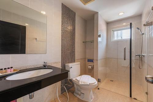 a bathroom with a toilet and a sink and a shower at Le Nara Residence in Jomtien Beach