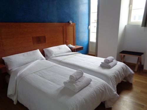 two beds in a hotel room with towels on them at Hotel Villa De Betanzos in Betanzos