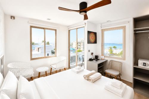 a bedroom with a white bed with a view of the ocean at Avyanna Gulhi Beach Hotel in Gulhi