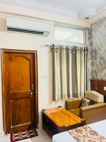 a living room with a couch and a door at Hotel Natraj Palace in Seonī