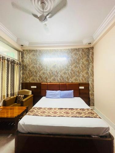 a bedroom with a large bed and a desk at Hotel Natraj Palace in Seonī