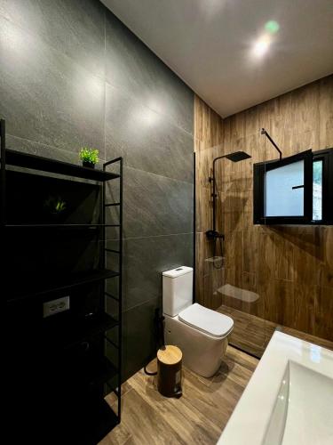 a bathroom with a toilet and a tv on the wall at Aries Villa Albania in Vorë