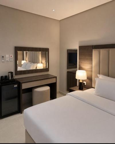 a hotel room with a bed and a television at جودول للشقق المخدومة in Khafji
