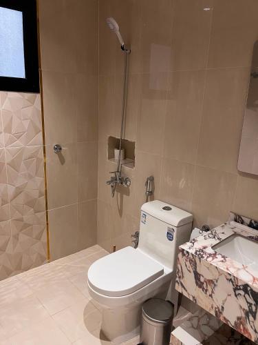 a bathroom with a toilet and a sink at جودول للشقق المخدومة in Khafji