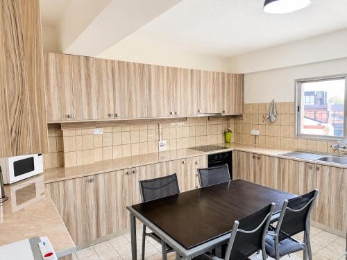 a kitchen with a black table and chairs in it at Swift Hostel Limassol in Limassol