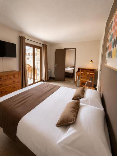 a bedroom with a large bed with pillows on it at Hôtel Le Chastellan in Valberg