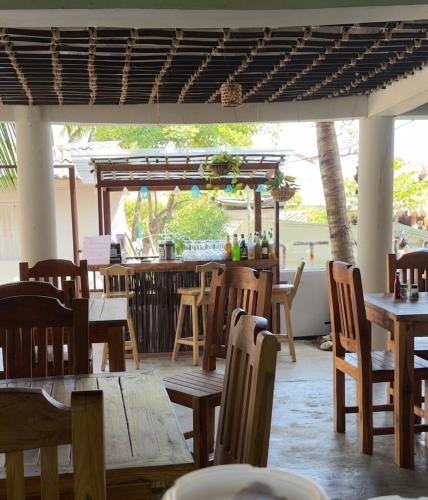 a restaurant with wooden tables and chairs and a bar at ECOHOTEL LILI in Puerto Limón