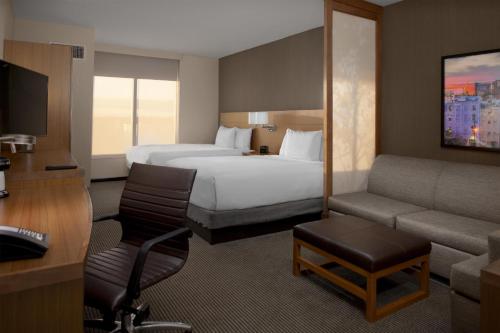 a hotel room with a bed and a couch at Hyatt Place Athens Downtown in Athens