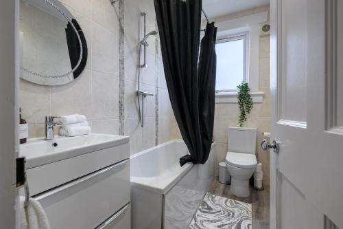 a bathroom with a sink and a toilet and a mirror at Sandyhill, St. Andrews in Fife