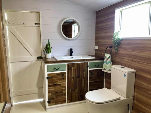 a bathroom with a toilet and a sink and a mirror at Jack's Tidal Pool Shack in Kingscote