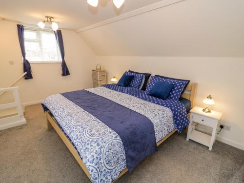 a bedroom with a large bed with blue pillows at The Cottage in Stratford-upon-Avon