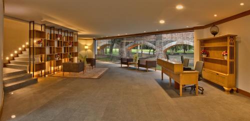 a lobby with a staircase and a table and chairs at Hacienda Jurica by Brisas in Querétaro