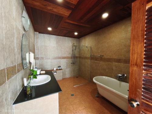 ein Badezimmer mit Badewanne, Waschbecken und Badewanne in der Unterkunft Pakse hotel & Restaurant in Pakse