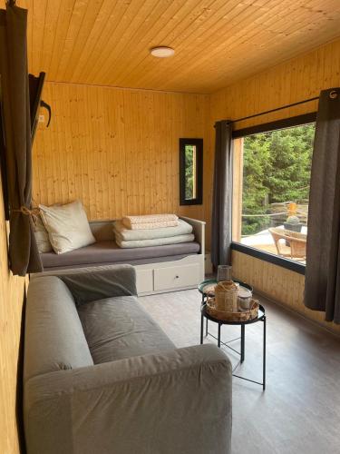 a living room with a couch and a window at TINY Klíny in Klíny