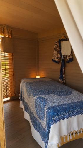 a bedroom with a bed with a blue and white blanket at Entre Mer & Filles in Sainte-Soulle
