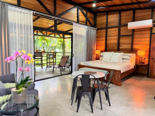 a bedroom with a bed and a table and chairs at Arenal Rain Forest Lodge in Fortuna