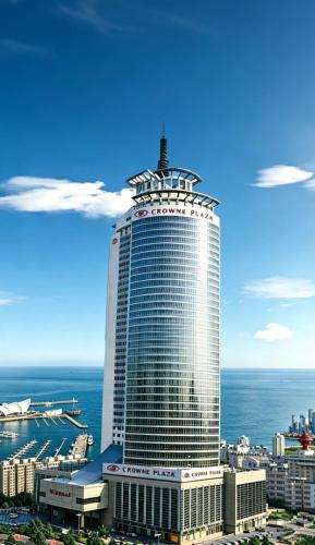 a large building with a sign on top of it at Crowne Plaza Qingdao by IHG in Qingdao