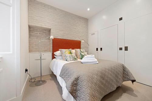 a bedroom with a bed with a red headboard at Grange Cottage in Galashiels