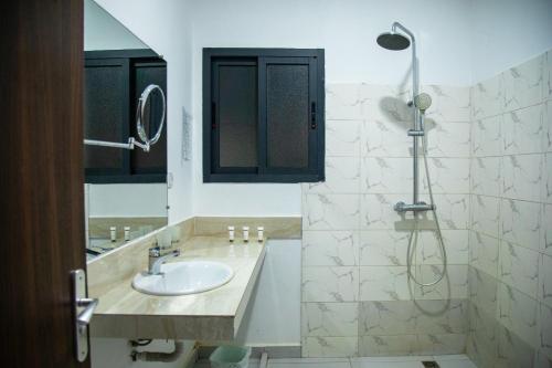 a bathroom with a sink and a shower at Madigane Residence Assinie in Assinie